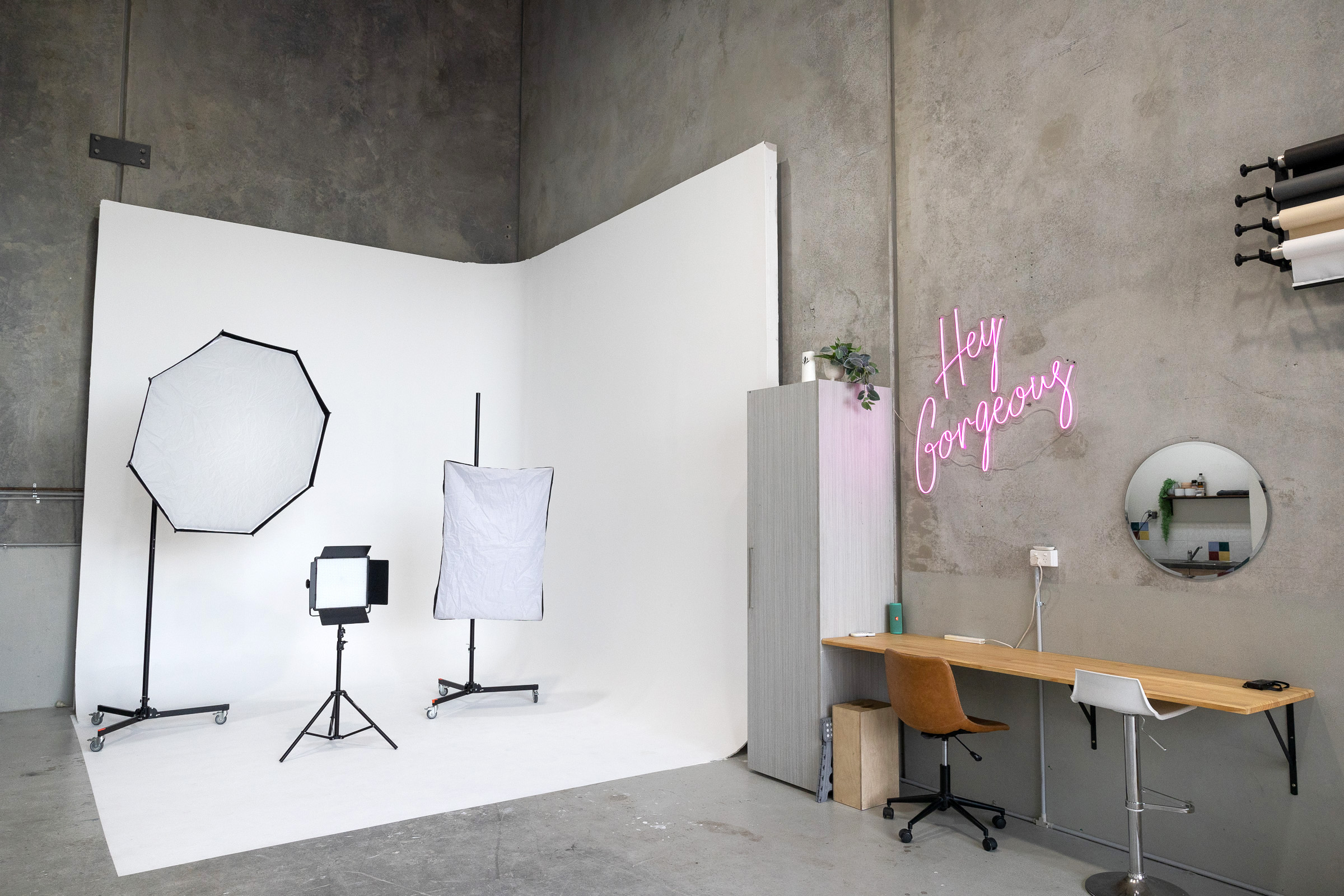 white corner cyclorama photography studio with lighting and with production desk to the right side